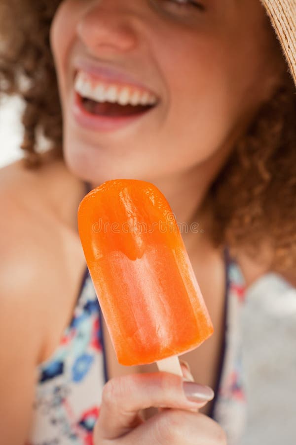 Померанцовый popsicle, котор держит ся молодая женщина стоковая фотография