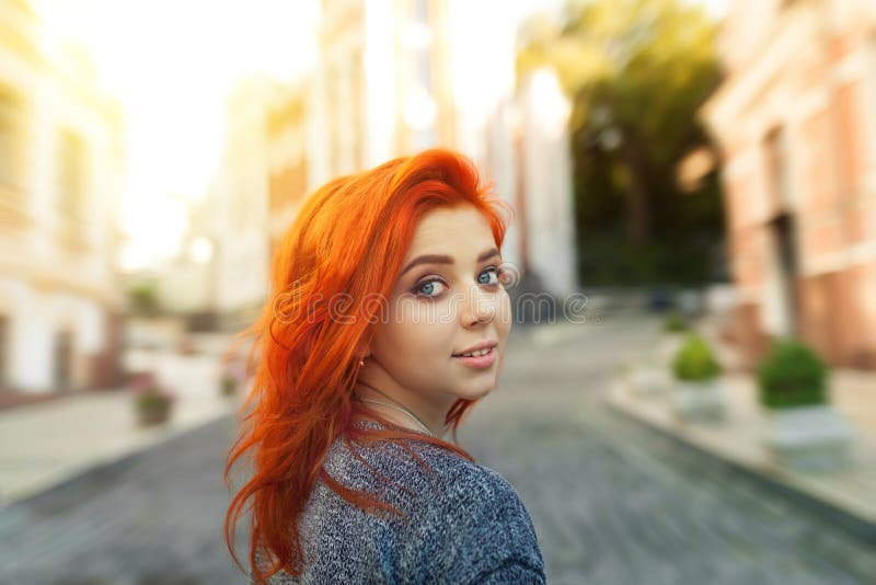 Поражанная молодая женщина redhead рассматривая назад ее плечо на камере по мере того как она гуляет вниз с дезертированной город стоковые изображения Поражанная молодая женщина redhead рассматривая назад ее плечо на камере по мере того как она гуляет вниз с дезертированной город стоковые изображения