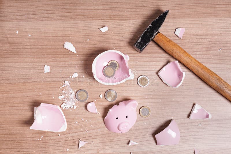 broken Piggy bank smashed into pieces with hammer and small or loose change euro coins. broken Piggy bank smashed into pieces with hammer and small or loose change euro coins