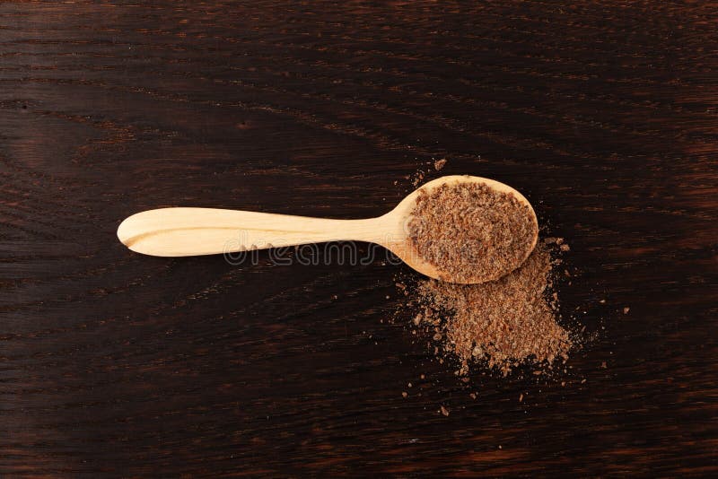 Milk Thistle powder or Silybum marianum extract in wooden spoon on brown wooden background. Herbal superfood for aiding liver function. Natural antioxidant. Milk Thistle powder or Silybum marianum extract in wooden spoon on brown wooden background. Herbal superfood for aiding liver function. Natural antioxidant.