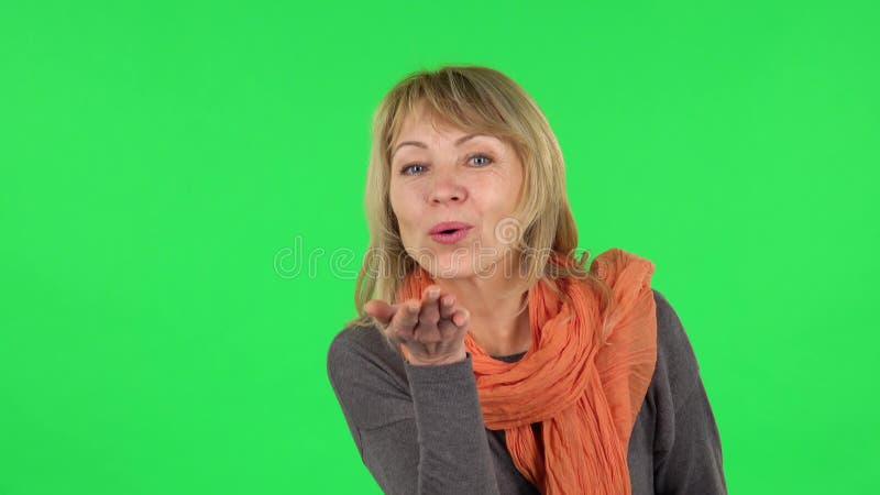 Портрет женщины, достигшей возраста к середине белокурой улыбаясь и говорит о том, что сердце с пальцами, а затем разжигающих поце видеоматериал