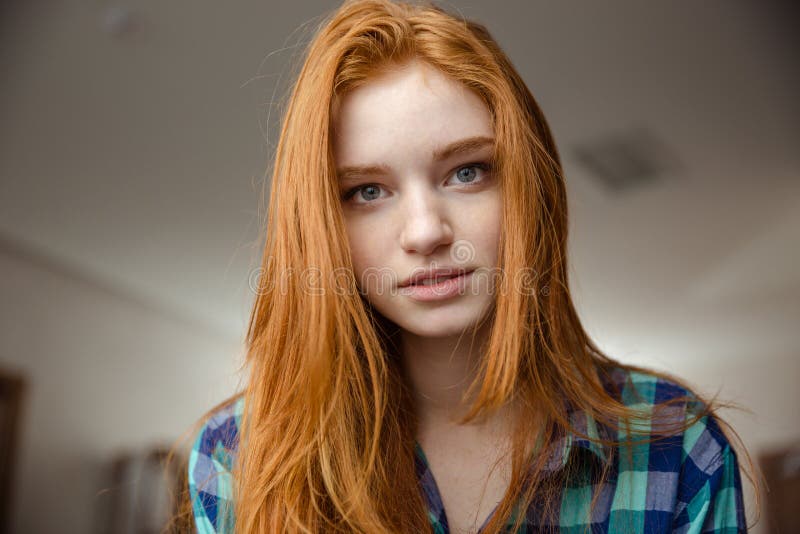Портрет заботливой привлекательной молодой женщины redhead в рубашке шотландки стоковая фотография Портрет заботливой привлекательной молодой женщины redhead в рубашке шотландки стоковая фотография