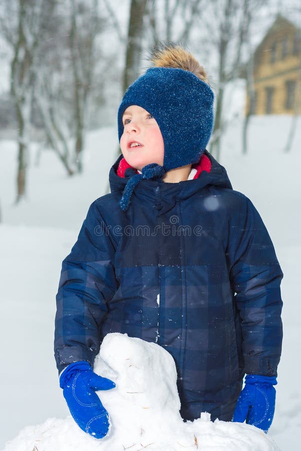 Портрет мальчика в зиме ребенок одет в одеждах шляпе, куртке и mittens зимы стоковое фото rf Портрет мальчика в зиме ребенок одет в одеждах шляпе, куртке и mittens зимы стоковое фото rf