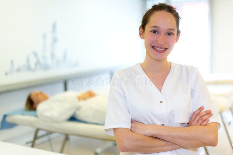 Портрет молодого привлекательного masseuse в профессиональной комнате стоковое фото Портрет молодого привлекательного masseuse в профессиональной комнате стоковое фото