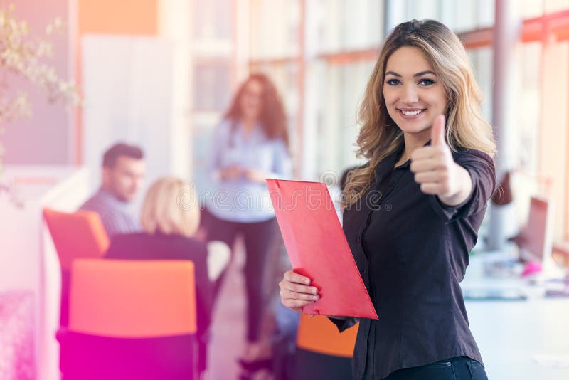 Портрет молодой бизнес-леди на современном startup интерьере офиса показывая большие пальцы руки вверх стоковое изображение rf Портрет молодой бизнес-леди на современном startup интерьере офиса показывая большие пальцы руки вверх стоковое изображение rf