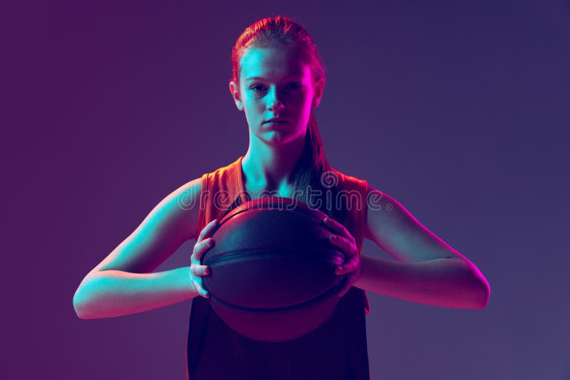 портрет молодой спортивной девушки-подростка, позирующей с помощью мяча, изолированного от градиента розового