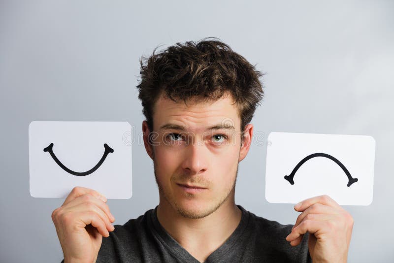 Portrait of a Questioning Man Holding Happy and Unhappy Survey Mood Board. Portrait of a Questioning Man Holding Happy and Unhappy Survey Mood Board