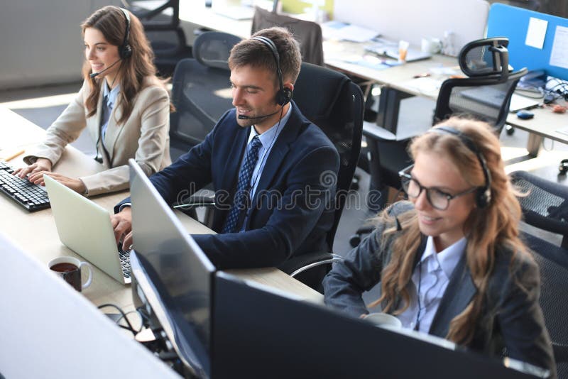 Портрет работника call-центра в сопровождении его команды Улыбка оператора поддержки клиентов на работе стоковые фото Портрет работника call-центра в сопровождении его команды Улыбка оператора поддержки клиентов на работе стоковые фото