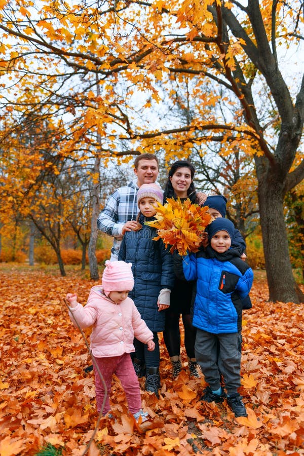 портрет семьи с детьми в осеннем городском парке счастливые люди, позирующие рядом с большим деревом красивой природой стоковые фото