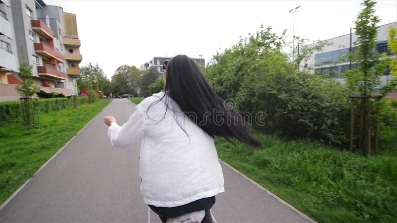 Портрет счастливой молодой женщины на велосипеде Она распространила ее красивые волосы