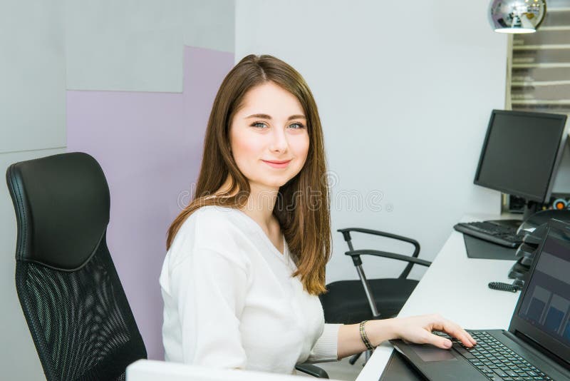 Портрет умелого административного менеджера работая на портативном компьютере в офисе удовлетворяемом с занятием, молодым женским стоковое изображение rf Портрет умелого административного менеджера работая на портативном компьютере в офисе удовлетворяемом с занятием, молодым женским стоковое изображение rf