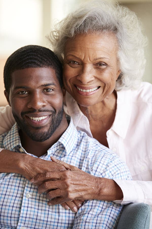 Portrait Of Smiling Senior Mother Hugging Adult Son At Home. Portrait Of Smiling Senior Mother Hugging Adult Son At Home