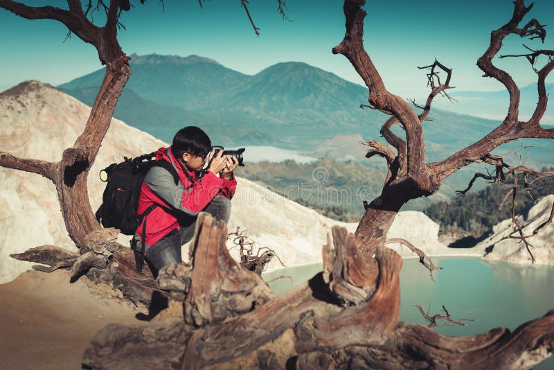 Портрет фотографии путешественника снимает изображение ландшафта на вулкане Kawah Ijen, национальном парке Индонезии , На открыто стоковая фотография