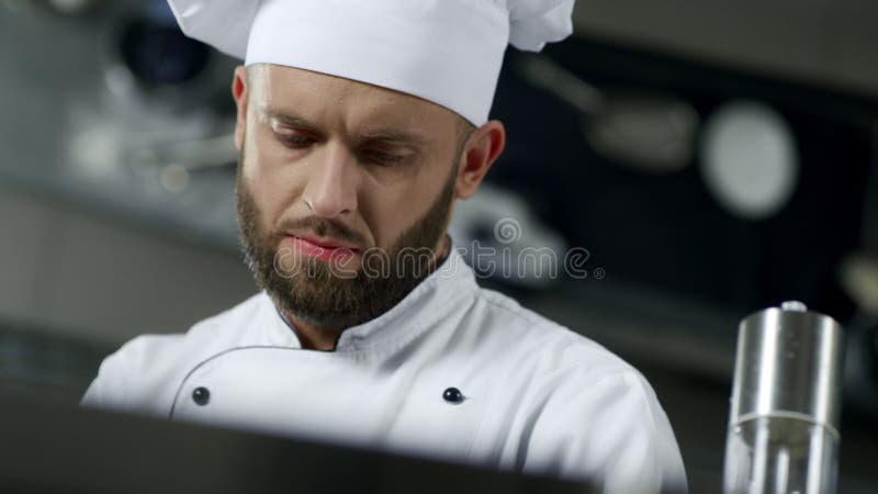 Портрет человека шеф-повара на профессиональной кухне Шеф-повар варя еду в замедленном движении