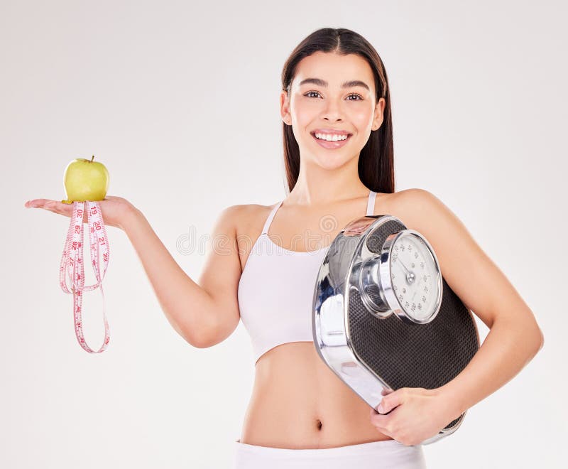 Portrait, tape measure or girl with apple or scale for healthy snack, nutrition diet or digestion benefits. Happy woman, lose weight or fitness model with smile or fruit in studio on white background. Portrait, tape measure or girl with apple or scale for healthy snack, nutrition diet or digestion benefits. Happy woman, lose weight or fitness model with smile or fruit in studio on white background.