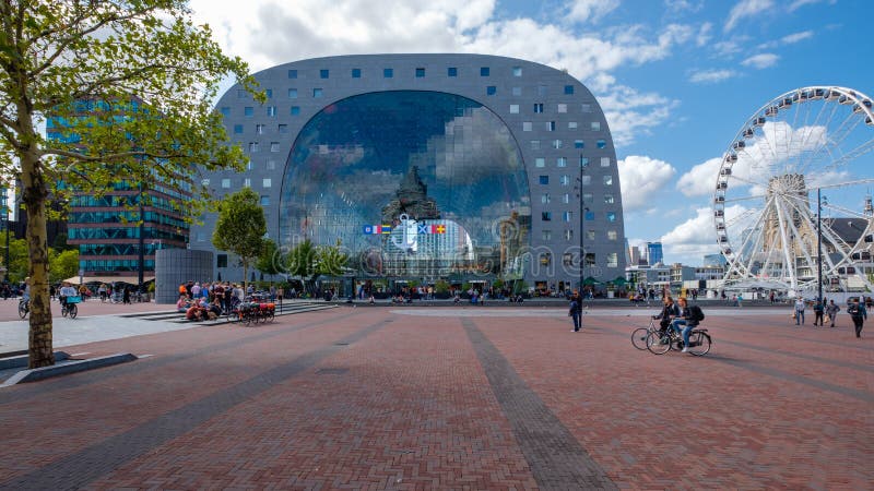 Посмотрите до конца от внешней стороны залы рынка в Роттердаме Колесо Ferris рядом с зданием и людьми и велосипедистами стоковое изображение Посмотрите до конца от внешней стороны залы рынка в Роттердаме Колесо Ferris рядом с зданием и людьми и велосипедистами стоковое изображение