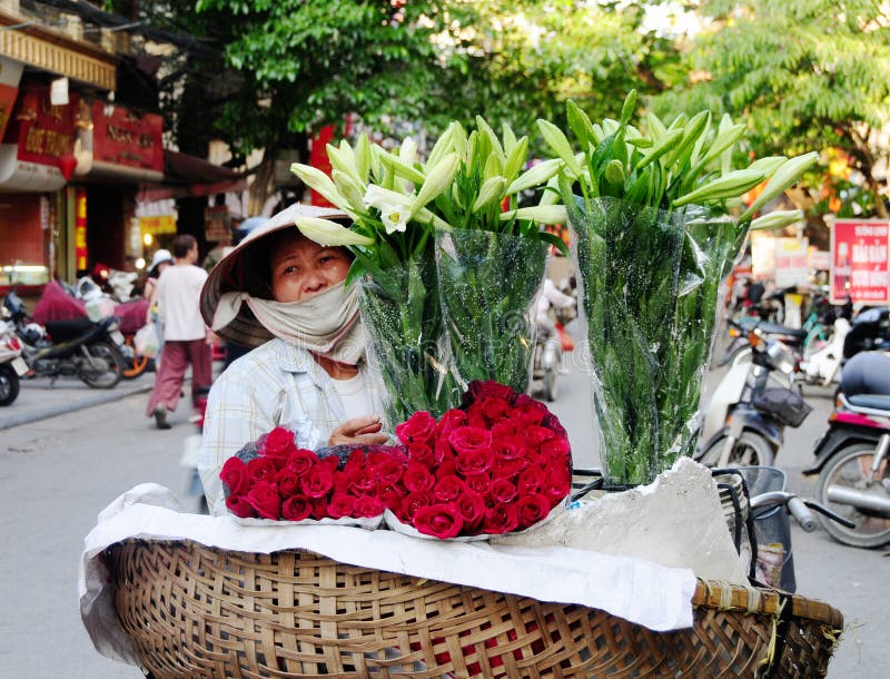 Поставщик продавая цветки на улице в Ханое, Вьетнаме