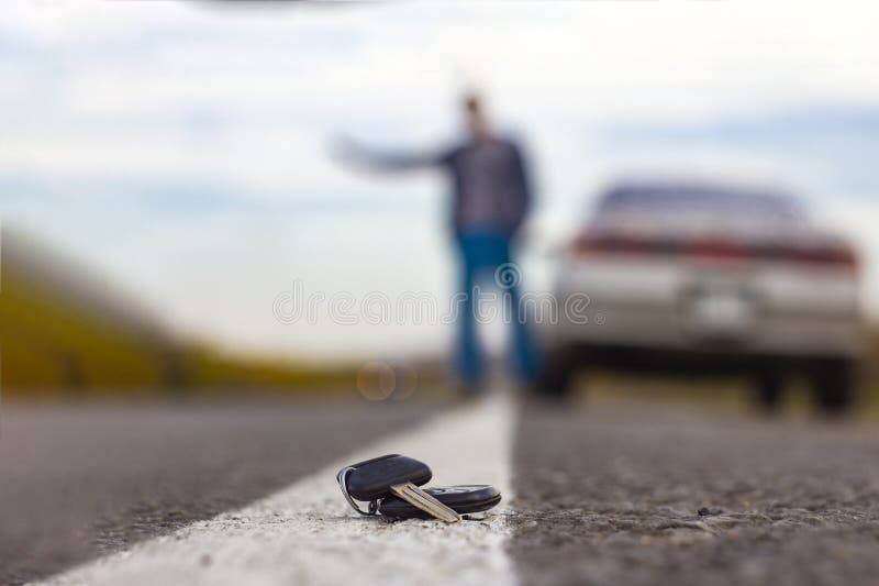Потерянные ключи автомобиля лежа на проезжей части, на запачканной предпосылке с влиянием bokeh стоковая фотография rf Потерянные ключи автомобиля лежа на проезжей части, на запачканной предпосылке с влиянием bokeh стоковая фотография rf