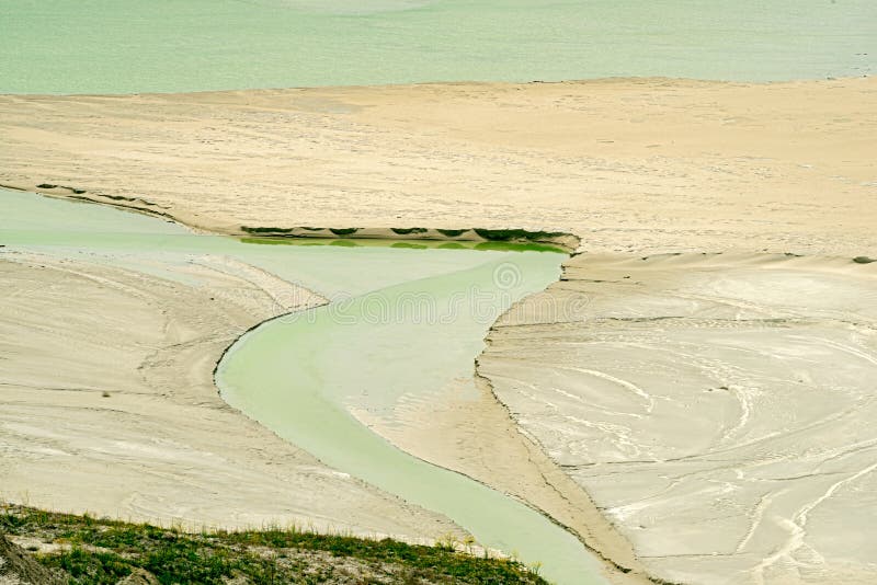 Water flows through sediment on the edge of a tailings pond at a copper mine near Ashcroft in British Columbia, Canada. Water flows through sediment on the edge of a tailings pond at a copper mine near Ashcroft in British Columbia, Canada