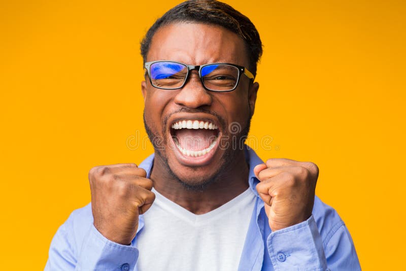 Yes. Emotional Black Man Screaming And Shaking Fists Rejoicing Victory And Success Standing On Orange Background. Studio Shot. Yes. Emotional Black Man Screaming And Shaking Fists Rejoicing Victory And Success Standing On Orange Background. Studio Shot