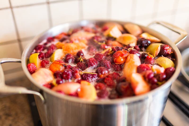 Потушенный плод и ягоды варя в лотке в кухне Русские ягоды Компот от персика, яблока, вишни и клубники r стоковая фотография rf Потушенный плод и ягоды варя в лотке в кухне Русские ягоды Компот от персика, яблока, вишни и клубники r стоковая фотография rf