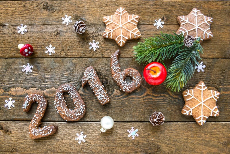 Предпосылка рождества с пряником 2016, ветви ели и украшения на старой деревянной доске стоковая фотография rf Предпосылка рождества с пряником 2016, ветви ели и украшения на старой деревянной доске стоковая фотография rf