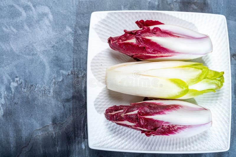 Предпосылка еды, плоская положенная концепция со свежим зеленым бельгийским эндивием или цикорий и красные овощи Radicchio, также стоковая фотография Предпосылка еды, плоская положенная концепция со свежим зеленым бельгийским эндивием или цикорий и красные овощи Radicchio, также стоковая фотография
