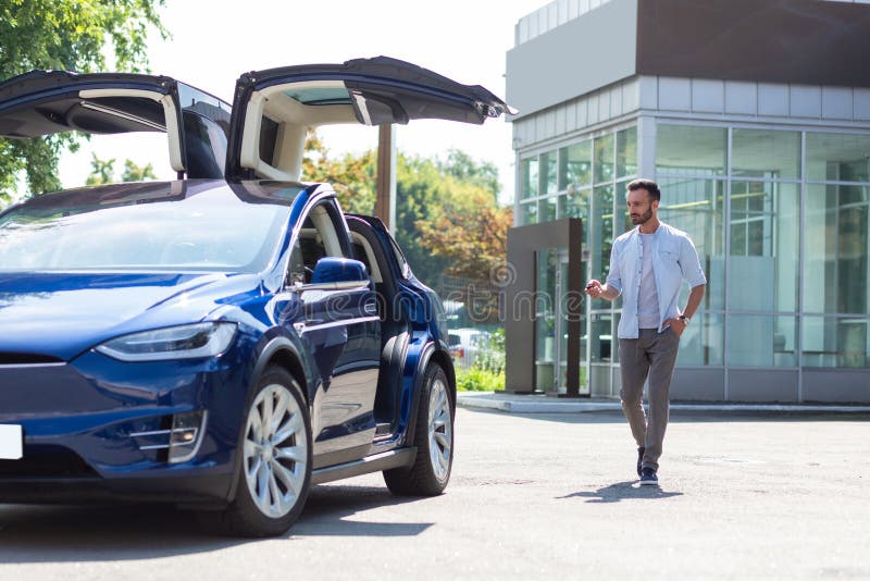 Предприниматель, медвежий темноволосый, идущий к своей машине стоковое фото