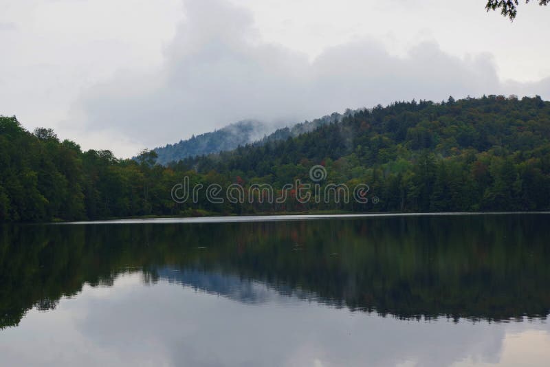 Предыдущая листва осени на туманном озере в горах Adirondack северной части штата Нью-Йорка стоковые фотографии rf