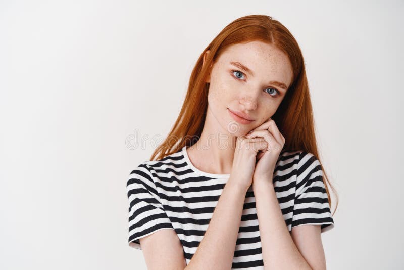 Прекрасная девушка с волосами и голубыми глазами ginger с восхищением глядя на лице и на руках и наклонности камеры стоковые изображения