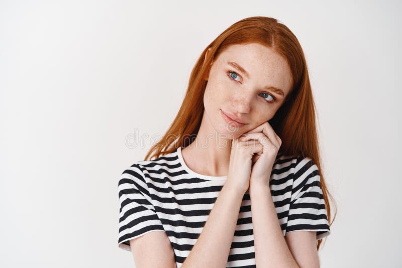 Прекрасная девушка с волосами и голубыми глазами ginger с восхищением глядя на лице и на руках и глядя склонности камеры стоковое изображение rf