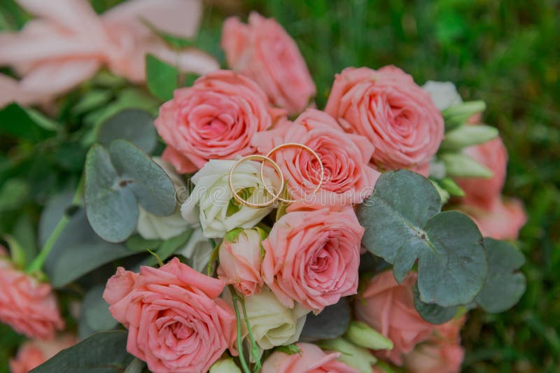 прекрасный букет свежих цветов на зелёной траве в день свадьбы. красивые розовые цветы. закрыть