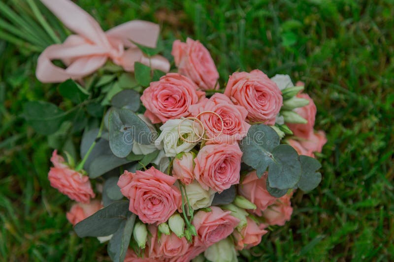 прекрасный букет свежих цветов на зелёной траве в день свадьбы. красивые розовые цветы