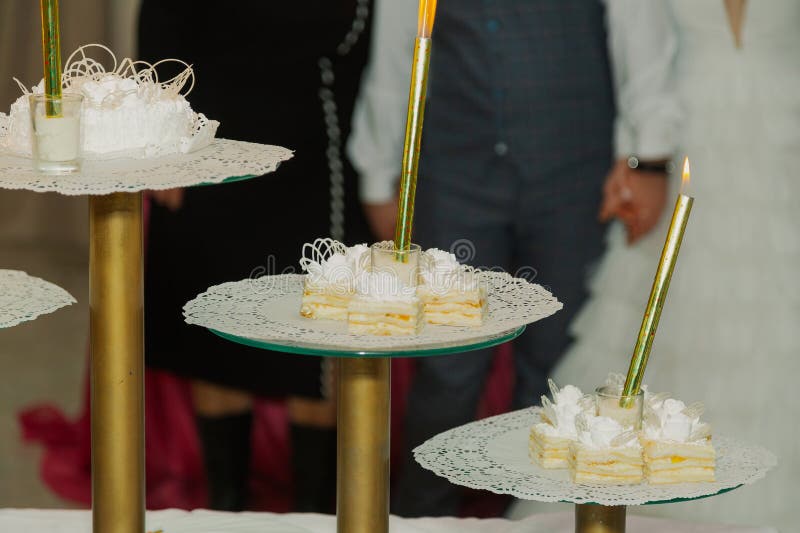 прекрасный свадебный торт на свадьбе с светящимися огнями. молодожены на заднем плане