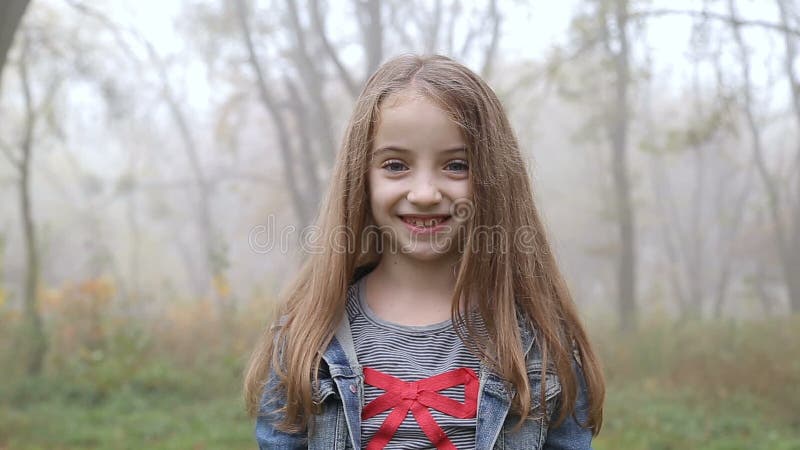 Прелестная маленькая девочка усмехается в камеру