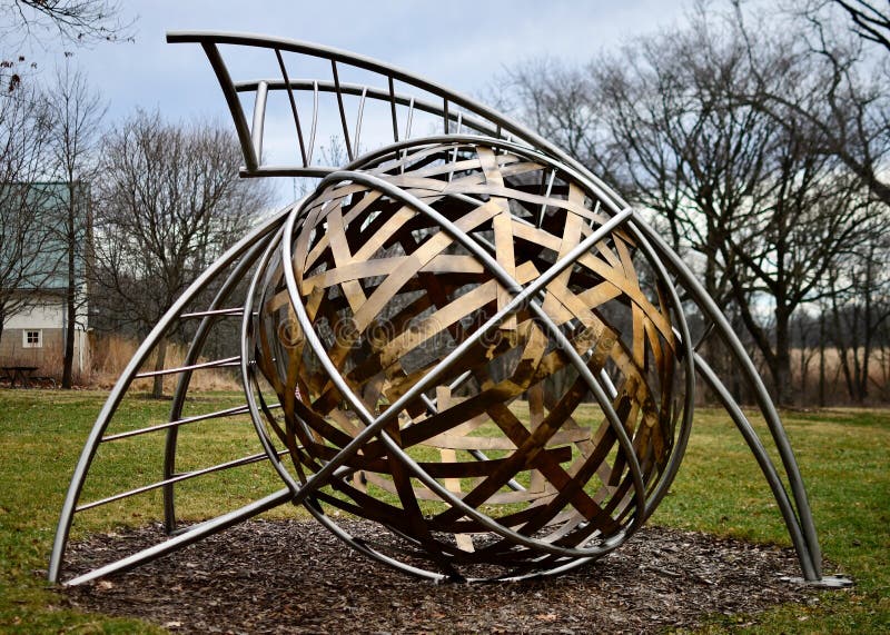 This is a Winter picture of a piece of public art titled: Transformation, on exhibit at Wendell Sculpture Garden at Meadowbrook Park located in Urbana, Illinois in Champaign County. This stainless steel and bronze sculpture was created by Fisher Stolz in 2012. This picture was taken on January 4, 2019. This is a Winter picture of a piece of public art titled: Transformation, on exhibit at Wendell Sculpture Garden at Meadowbrook Park located in Urbana, Illinois in Champaign County. This stainless steel and bronze sculpture was created by Fisher Stolz in 2012. This picture was taken on January 4, 2019.