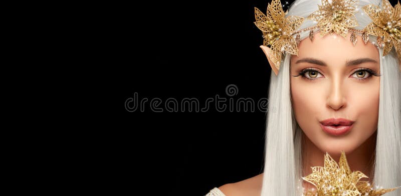 Attractive elf queen with golden flowers looking at camera while sending a kiss. Fairy tale and elves concept for carnivals isolated on black. Beautiful young woman in elf or fairy costume. Attractive elf queen with golden flowers looking at camera while sending a kiss. Fairy tale and elves concept for carnivals isolated on black. Beautiful young woman in elf or fairy costume