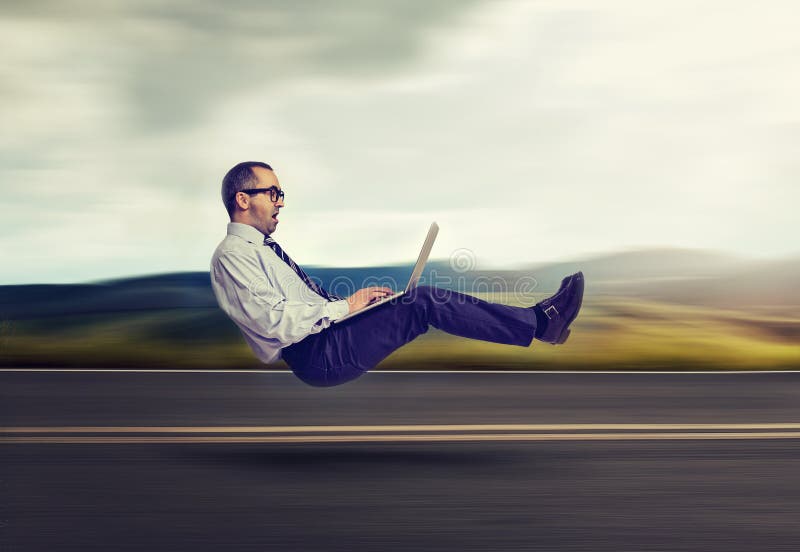 принципиальная схема голодает интернет Levitating бизнесмен на дороге используя портативный компьютер стоковое фото принципиальная схема голодает интернет Levitating бизнесмен на дороге используя портативный компьютер стоковое фото