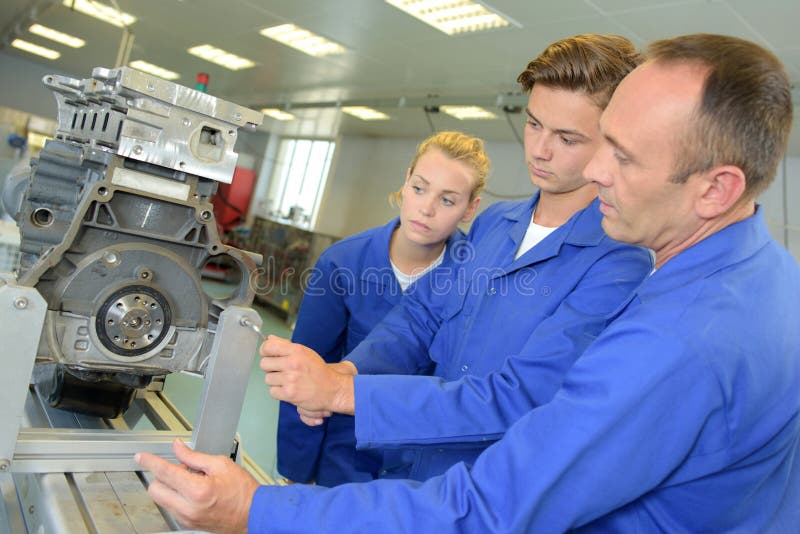 2 apprentice adjusting the machinery. 2 apprentice adjusting the machinery