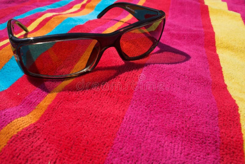 Sunglasses on a colorful beach towel. Sunglasses on a colorful beach towel