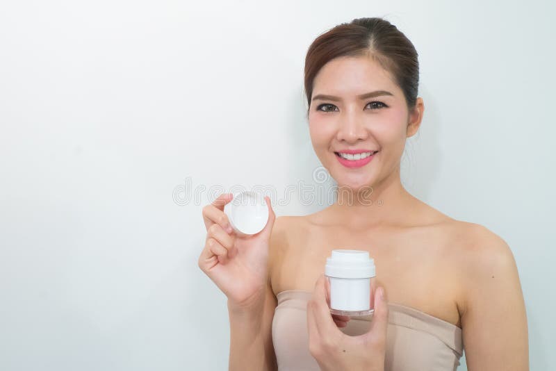 Продукты Skincare, портрет красивой молодой женщины смотря стоковые изображения Продукты Skincare, портрет красивой молодой женщины смотря стоковые изображения