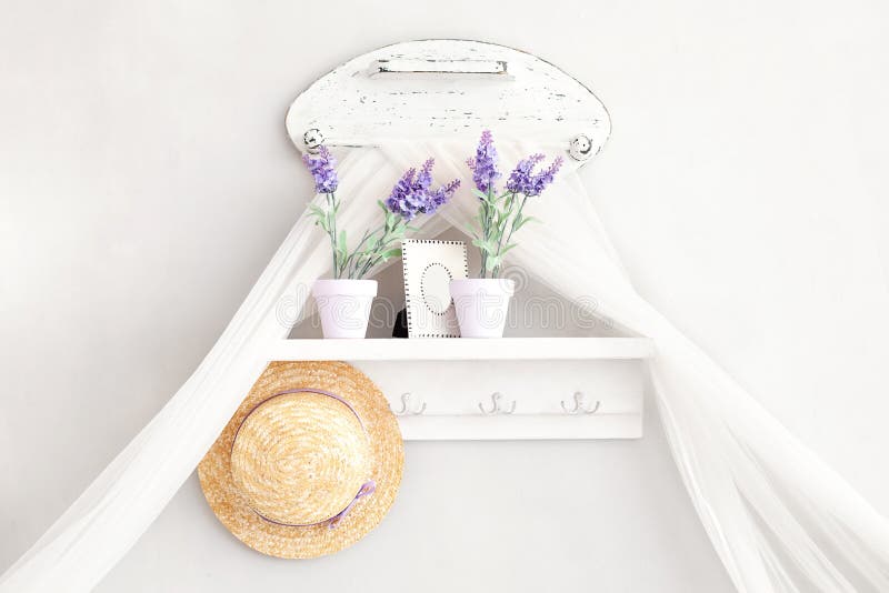 Provence, rustic style. Shabby chic in Provencal style. Village, country house. Shelf for hats, household trifles in a gentle French style on a white background. Key holder with lavender pots. Provence, rustic style. Shabby chic in Provencal style. Village, country house. Shelf for hats, household trifles in a gentle French style on a white background. Key holder with lavender pots