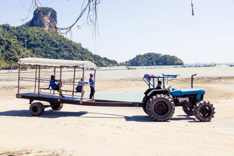 Провинция Krabi, Таиланд - 12-ое мая 2019: Особенный трактор с трейлером пассажира поставляет туристов и багажа к берегу стоковые фотографии rf Провинция Krabi, Таиланд - 12-ое мая 2019: Особенный трактор с трейлером пассажира поставляет туристов и багажа к берегу стоковые фотографии rf