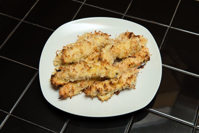 Цыпленок Crusted кокосом. Прокладки цыпленка покрытые с shredded кокосом и испеченные до золотистого коричневого цвета.