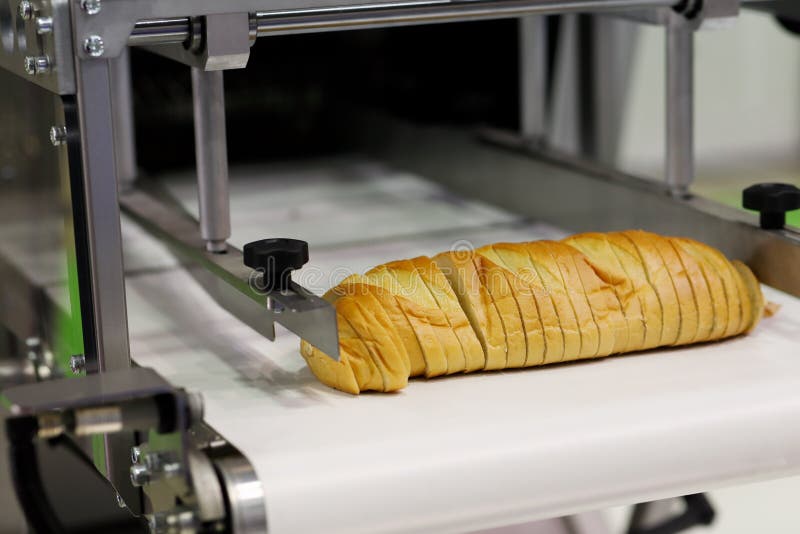 Промышленная автоматическая машина slicer хлеба стоковые фотографии rf Промышленная автоматическая машина slicer хлеба стоковые фотографии rf