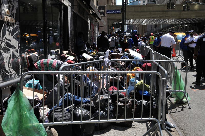 August 2, 2023: Asylum Seekers outside the Roosevelt Hotel in Midtown Manhattan in New York. Migrants fill sidewalk outside the hotel waiting to register for shelter and being provided Pizza. August 2, 2023: Asylum Seekers outside the Roosevelt Hotel in Midtown Manhattan in New York. Migrants fill sidewalk outside the hotel waiting to register for shelter and being provided Pizza.