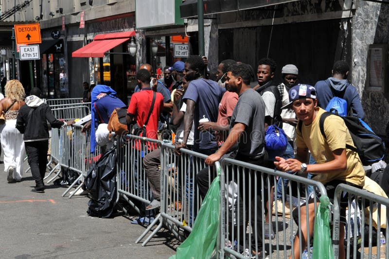 August 2, 2023: Asylum Seekers outside the Roosevelt Hotel in Midtown Manhattan in New York. Migrants fill sidewalk outside the hotel waiting to register for shelter and being provided Pizza. August 2, 2023: Asylum Seekers outside the Roosevelt Hotel in Midtown Manhattan in New York. Migrants fill sidewalk outside the hotel waiting to register for shelter and being provided Pizza.