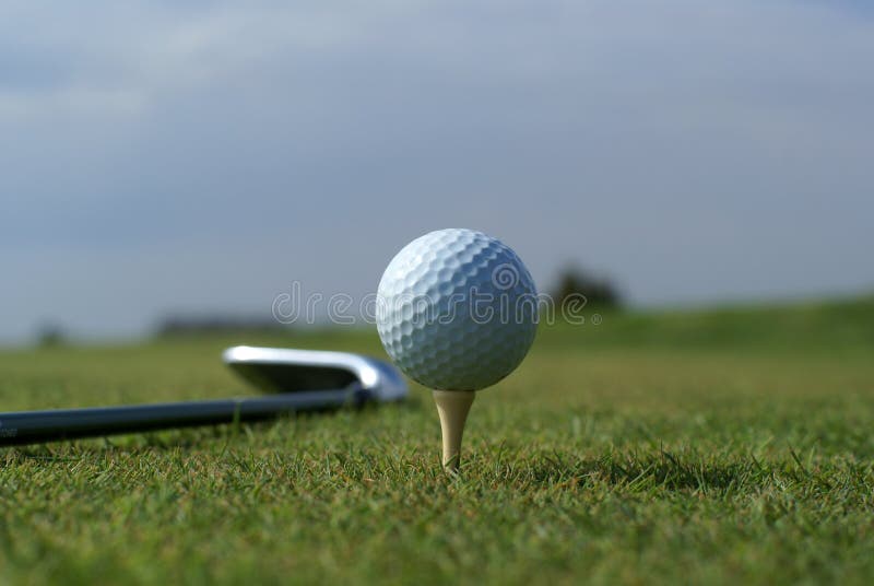 Golf ball in tall green grass set against blue sky. Golf ball in tall green grass set against blue sky