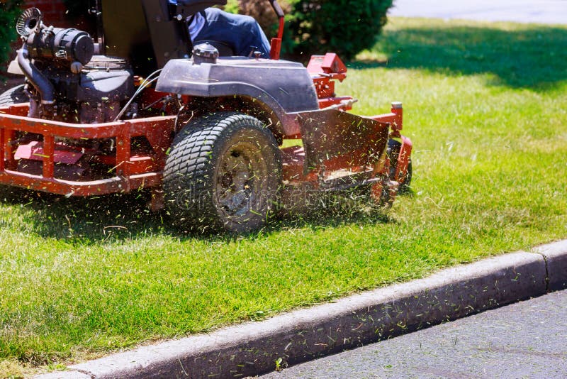 process of lawn mowing, lawnmower cutting grass with gardening tools and green grass around. process of lawn mowing, lawnmower cutting grass with gardening tools and green grass around