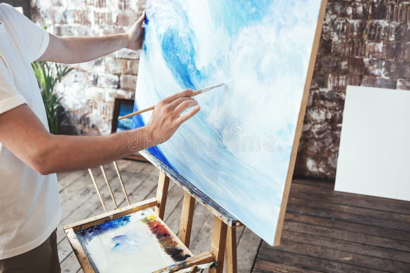 Процесс чертежа с oilpaints и paintbrush Краски художника на картине холста на мольберте в студии стоковое изображение rf Процесс чертежа с oilpaints и paintbrush Краски художника на картине холста на мольберте в студии стоковое изображение rf